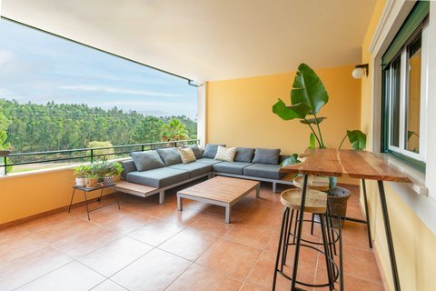 Varanda coberta com vista para árvores.