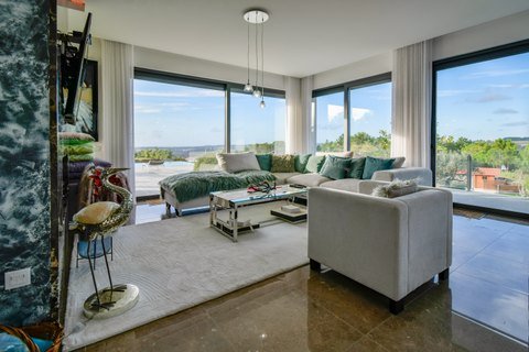 Sala de estar panorâmica com grandes janelas.